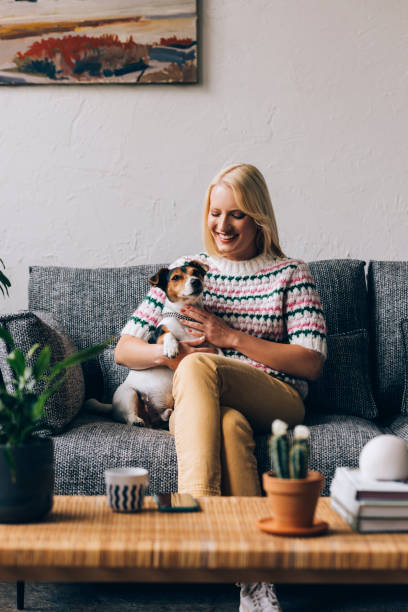 istock Happy Woman Relaxing With Her Dog at Sofa 1350092687