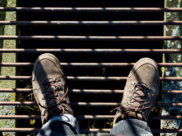 istock suede boots top view stand on an iron bridge over an abyss 1350092827