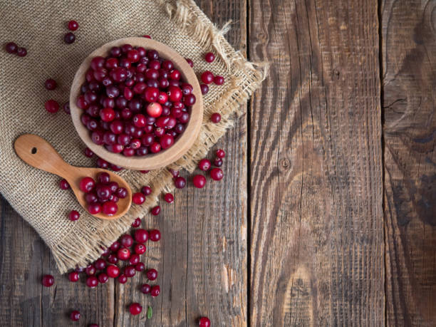 istock Ripe fresh cranberries in a wooden bowl on a rustic table top. 1350094789