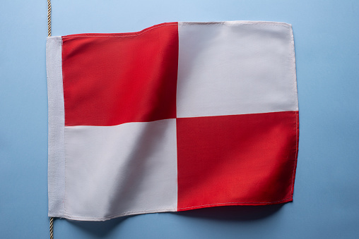 Flag of St George / St Georges cross, flag of England, flying on a white pole against a pure blue sky