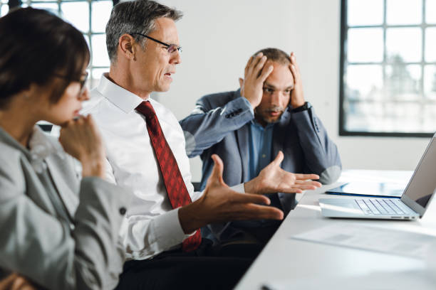 istock Business colleagues reading shocking e-mail on laptop in the office 1350097921