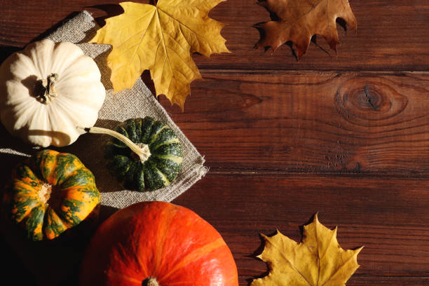 istock Autumn rustic composition. Pumpkins and leaves on the wooden table with copy space. Thanksgiving day concept. Top view, flat lay 1350100202