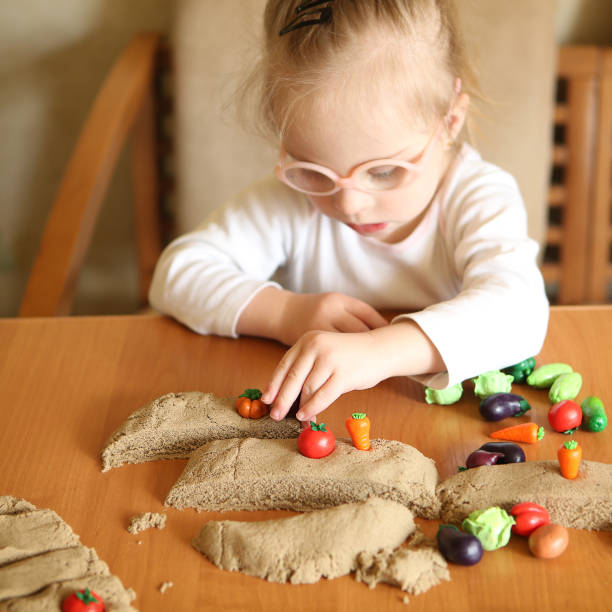 istock Girl with Down syndrome is involved in sorting vegetables 1350101121