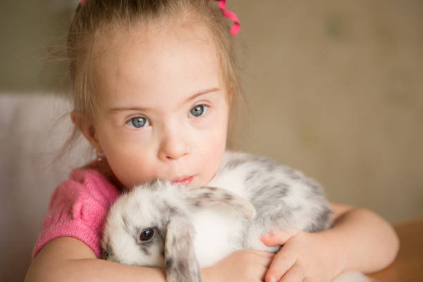 istock Girl with Down syndrome hugs rabbit 1350101158