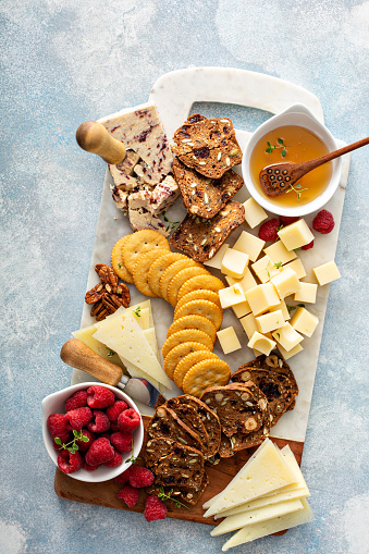 Cheese and snacks board with raspberry and crackers, summer Charcuterie board