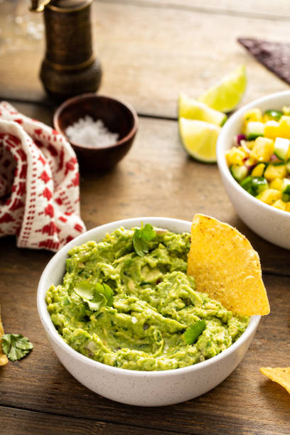 Chunky homemade guacamole in a bowl with tortilla chips Homemade guacamole freshly made with tortilla chips guacamole stock pictures, royalty-free photos & images