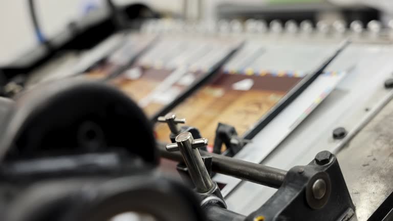 In the printing house, the automated machine cutting and stacking the printed media