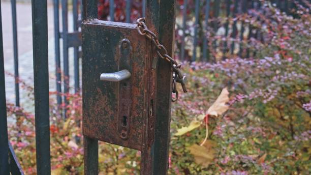 istock Rusty Metal Property Fence Gate With Damaged Lock and Broken Handle Secured with Iron Chain and Simple Padlock 1350118086