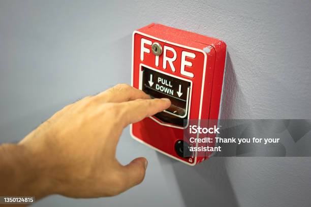 Action Of A People Is Activating The Emergency Fire Alarm Stock Photo - Download Image Now