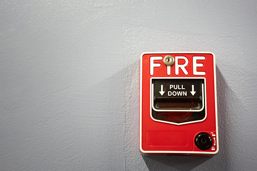 Fire alarm activation equipment box which is installed on the building wall. Close-up and selective focus on the object's part.