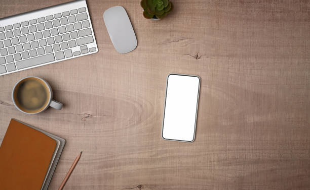istock Mock up smart phone with white screen on wooden table. 1350143770