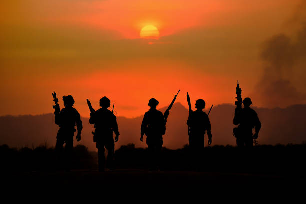 The silhouette of a military soldier with the sun as a Marine Corps for military operations stock photo