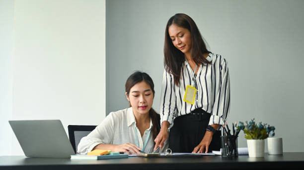 istock Two happy businesswomen analyzing business data together in office. 1350146264