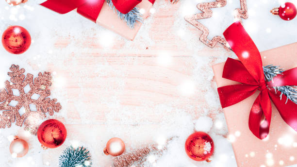 Xmas background table. Winter wooden decoration backdrop. Christmas board with old rustic wall, white frozen snow, golden balls and gift box. Minimal flat lay.