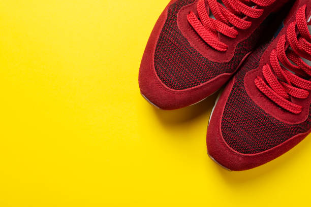 istock New red sneakers on a yellow background. space for text. 1350158303
