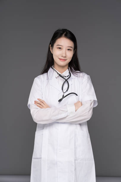 The young Chinese female doctor shook hands and looked at the camera with a smile stock photo