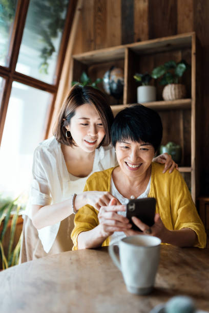 istock Affectionate Asian senior mother and daughter using smartphone together at home, smiling joyfully, enjoying mother and daughter bonding time. Multi-generation family and technology 1350164913