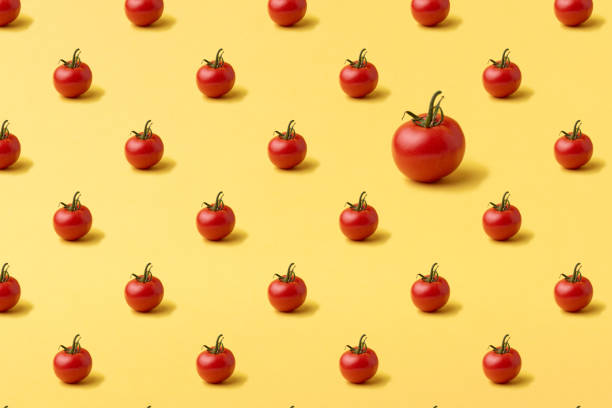 istock Colorful pattern of red tomatoes on yellow background. Vegans concept 1350167465
