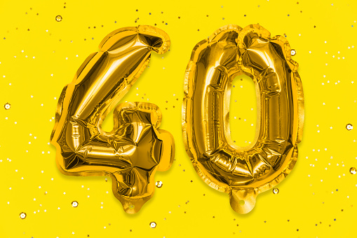 The number of the balloon made of golden foil, the number forty on a yellow background with sequins. Birthday greeting card with inscription 40. Numerical digit, Celebration event.