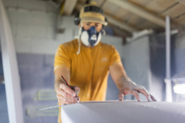 istock Surfboard Modeling Workshop - Man perfecting the modeling of a surfboard. Shaper Concept. 1350173677