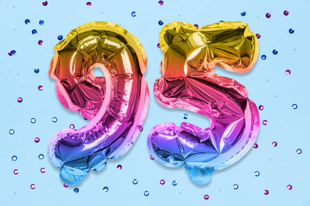 istock Rainbow foil balloon number, digit ninety five on a blue background with sequins. Birthday greeting card 1350173750