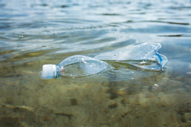 istock Used plastic bottle floating in clear water. 1350185422