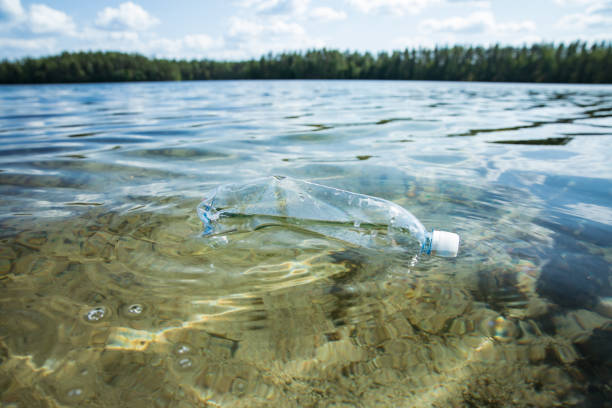 istock Used plastic bottle floating in clear water. 1350185634