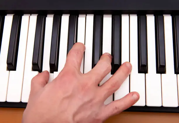 Hand and Piano Keyboard in the Room closeup