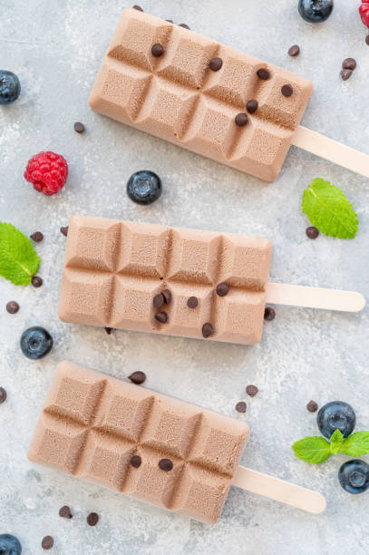 istock Homemade chocolate ice cream (popsicles) with fresh raspberry and blueberry on a gray background. copy space. 1350187249