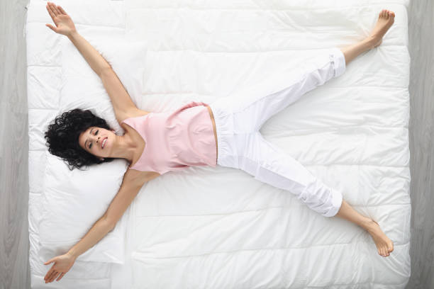 mujer elegir cama para dormitorio - colchones fotografías e imágenes de stock