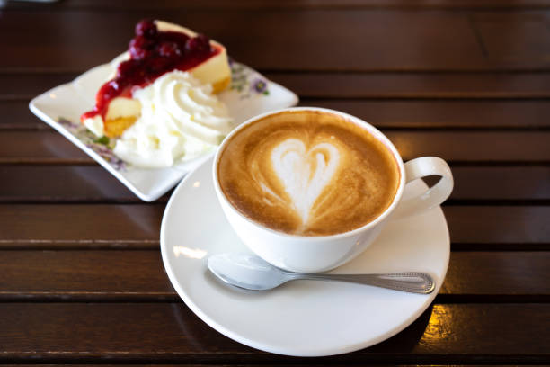 Latte coffee and blueberry cheese cake on wooden table