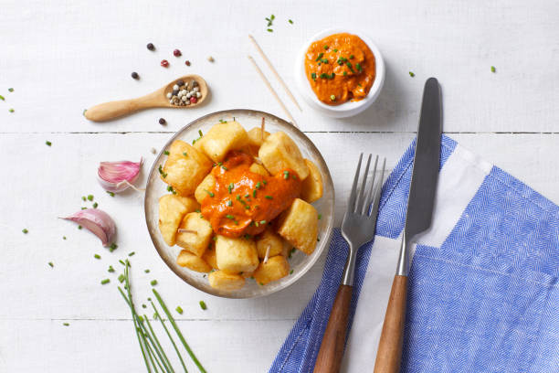 Spanish food Patatas bravas seen from above on a white wooden table patatas bravas stock pictures, royalty-free photos & images