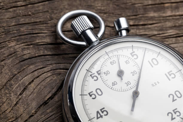 istock Stopwatch on old wooden background 1350198645