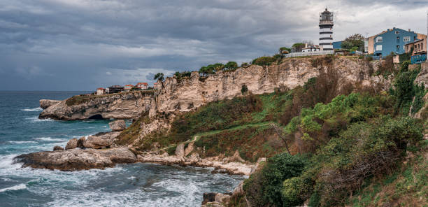 view of lighthouse at seashore against cloudy sky. beautiful lighthouse on the rocks near sile, istanbul, turkey, black sea. panorama - protection insurance dark rain imagens e fotografias de stock