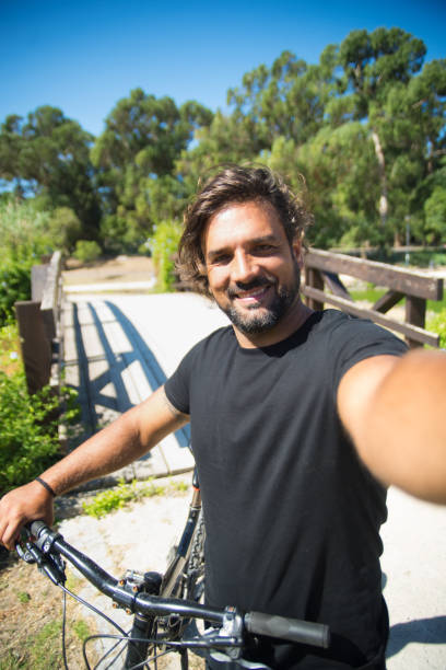 istock Handsome curly man taking selfie in park 1350200430