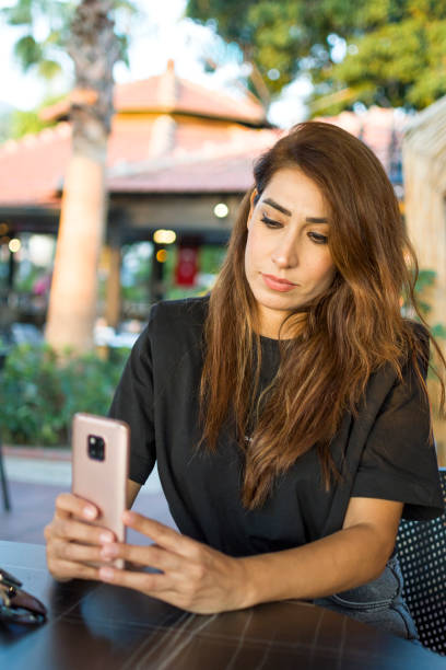 istock Beautiful woman using mobile phone outdoors 1350205758