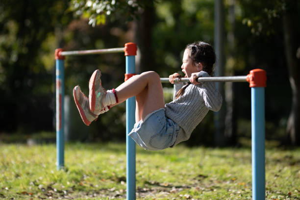 Girl playing horizontal bar in autumn park Girl playing horizontal bar in autumn park horizontal bar stock pictures, royalty-free photos & images