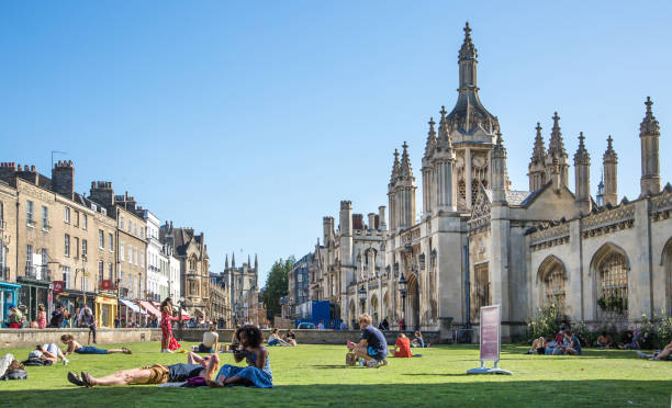 cambridge university king's college and chapel view with people relaxing on grass at hot sunny day - st johns college imagens e fotografias de stock