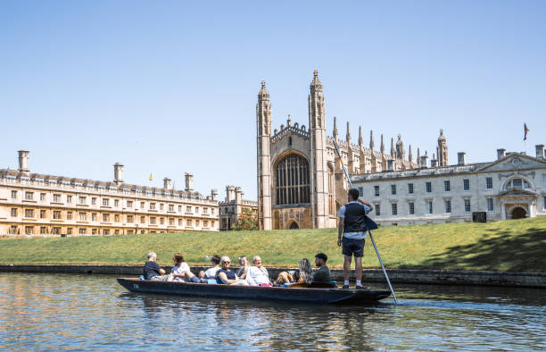 cambridge,  cambridge university king's college and chapel view from the river cam and punting boat with tourists - st johns college imagens e fotografias de stock