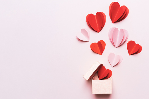 Fondo de San Valentín con corazones rojos y caja de regalo sobre fondo rosa con espacio de copia photo