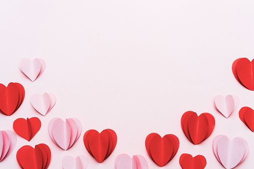 Valentine's Day background of greeting card with space for text, confetti and heart shaped cookies on pink background.