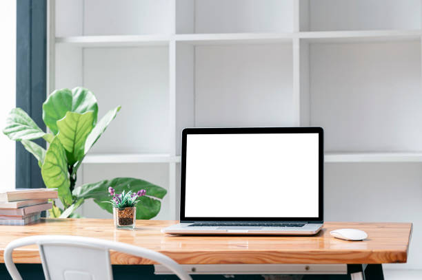 istock Blank screen laptop computer on wooden table in living room. 1350211178