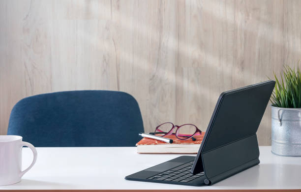 istock Comfortable workspace room with tablet computer on white top table and wooden wall. 1350212009