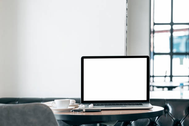 istock Mockup blank white screen laptop computer on wooden table in cafe room. 1350213604