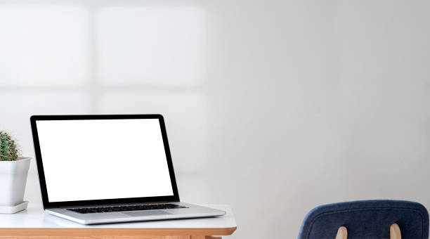 istock Mockup blank white screen laptop computer on the table in living room. 1350213715