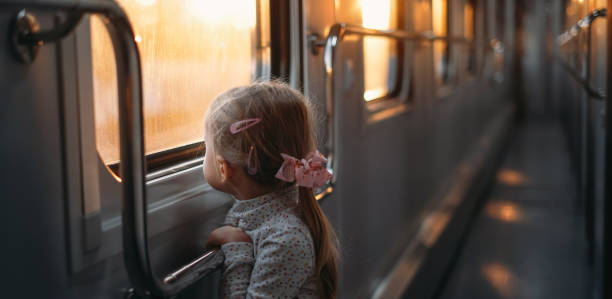 istock Girl, child looking though train window on sunset 1350215587