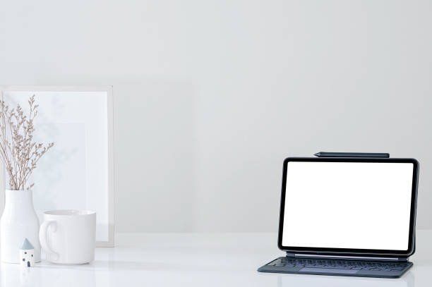 istock Mockup blank screen tablet with magic keyboard and decorate object on white table. 1350216173