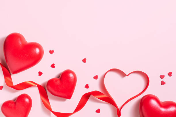istock Valentine's day background with heart shape decorations and ribbons. View from above. Flat lay composition on red 1350216505
