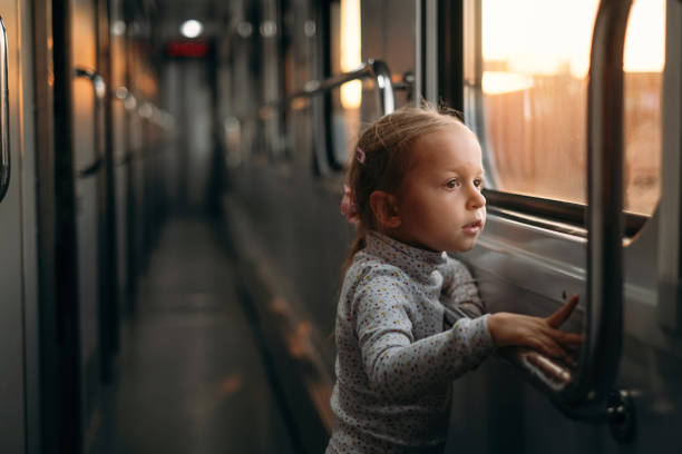 istock Girl, child looking though train window on sunset 1350217274