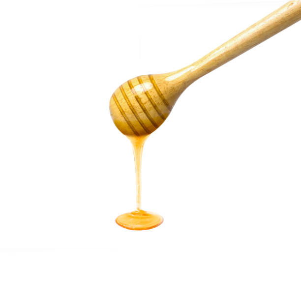 istock Honey dripping from wooden dipper 1350217370